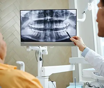 Doctor reviewing dental X Ray on monitors